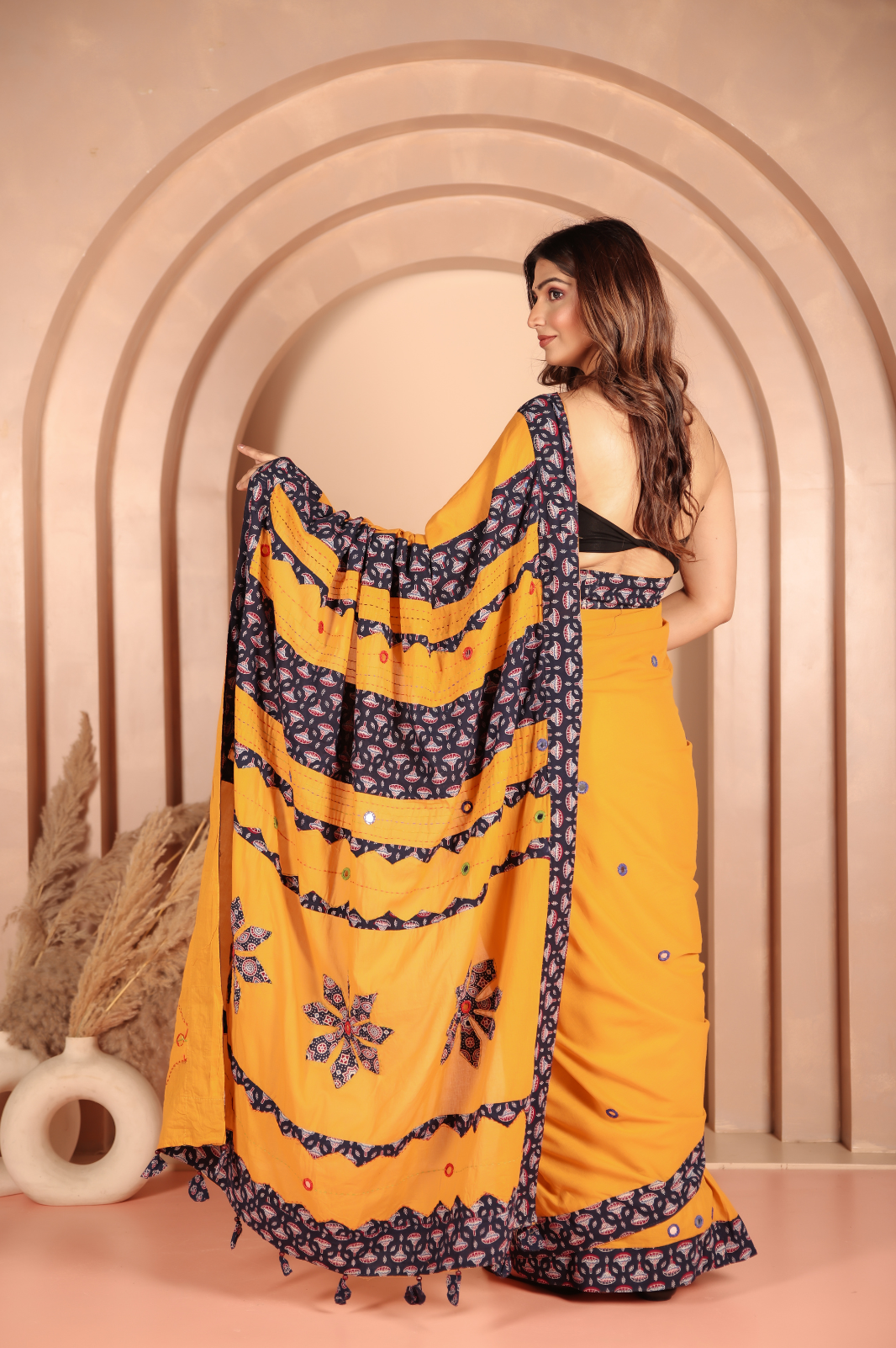 Mustard yellow saree features intricate applique work