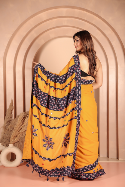 Mustard yellow saree features intricate applique work