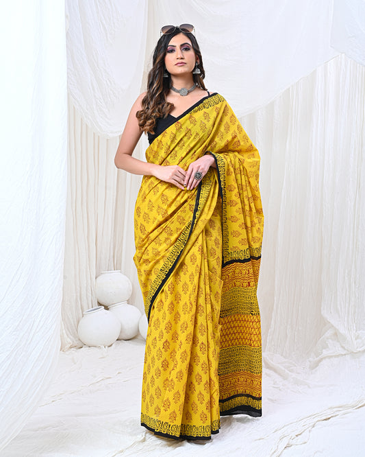 Traditional Indian cotton saree in vibrant yellow color, featuring intricate floral patterns